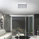 Moderne LED-Deckenleuchte im Wohnzimmer mit Glasfront, stilvoller Einrichtung und Blick auf Terrasse.