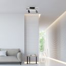 Modernes Wohnzimmer mit grauem Sofa, Beistelltisch, LED-Deckenstrahler und stilvoller Wandverkleidung.