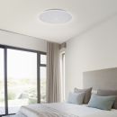 Moderne LED-Deckenleuchte mit Sternenhimmel-Effekt in hellem Schlafzimmer mit großen Fenstern und Doppelbett.