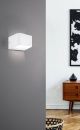 Moderne LED-Wandlampe in Weiß an grauer Wand, minimalistisches Wohnzimmer mit Holzkommode und abstrakter Kunst.