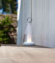 Moderne LED-Laterne aus Glas und Metall auf Holztisch im Garten bei Tageslicht, stilvolle Außenbeleuchtung.