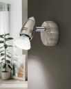 Moderne LED-Wandleuchte aus Edelstahl, schwenkbar, an grauer Wand im Wohnzimmer mit Pflanze im Hintergrund.